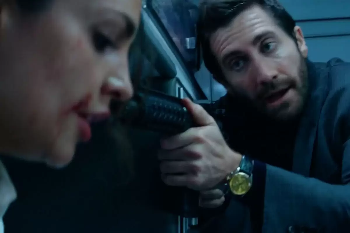 Jake Gyllenhaal aponta uma arma para a cabeça da atriz Eiza González em Ambulância: Um Dia de Crime.
