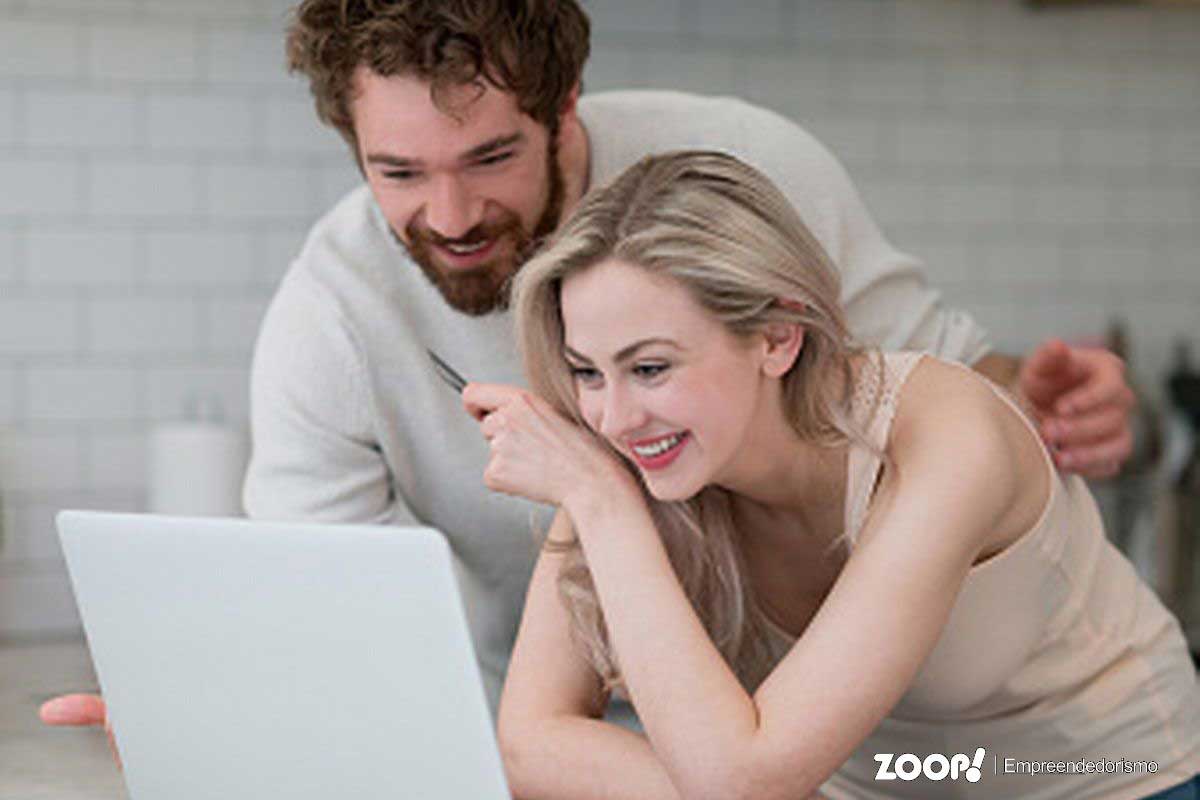 Casal jovem lendo matéria sobre o Programa Litígio Zero no Portal eZoop.com.