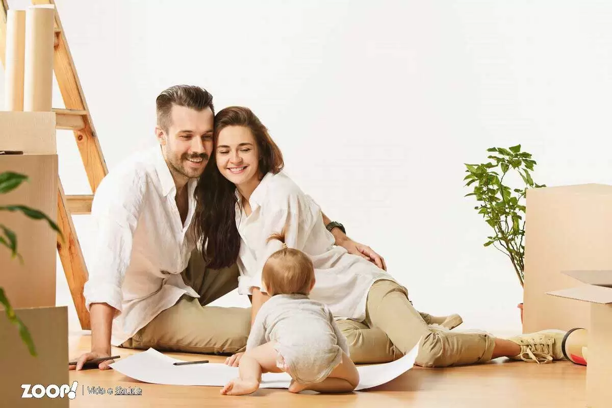 Casal jovem observa o bebê brincando ilustra nosso artigo sobre: O papel dos pais na autoestima dos filhos.