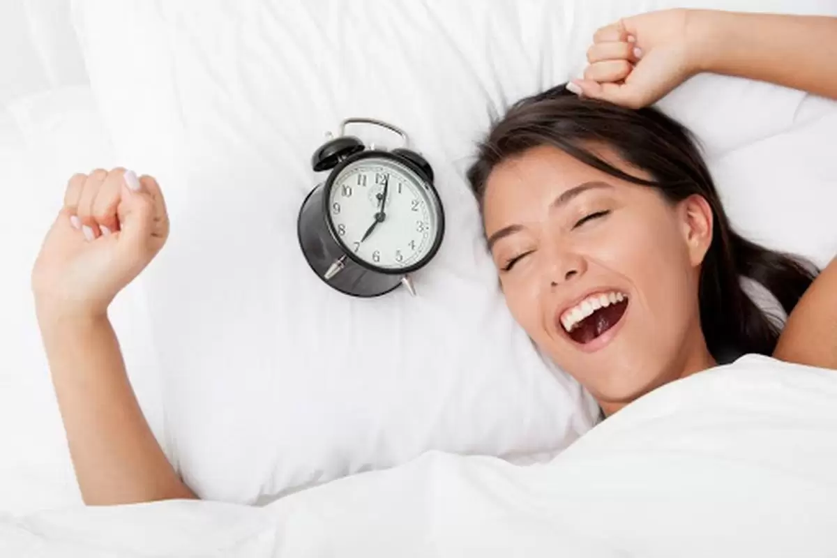 Uma mulher acordando feliz com o despertador ao lado ilustra nosso artigo sobre: Como dormir bem e acordar cheio de energia. (Foto: StockPhotos) Uma mulher acordando feliz com o despertador ao lado ilustra nosso artigo sobre: Como dormir bem e acordar cheio de energia. (Foto: StockPhotos)