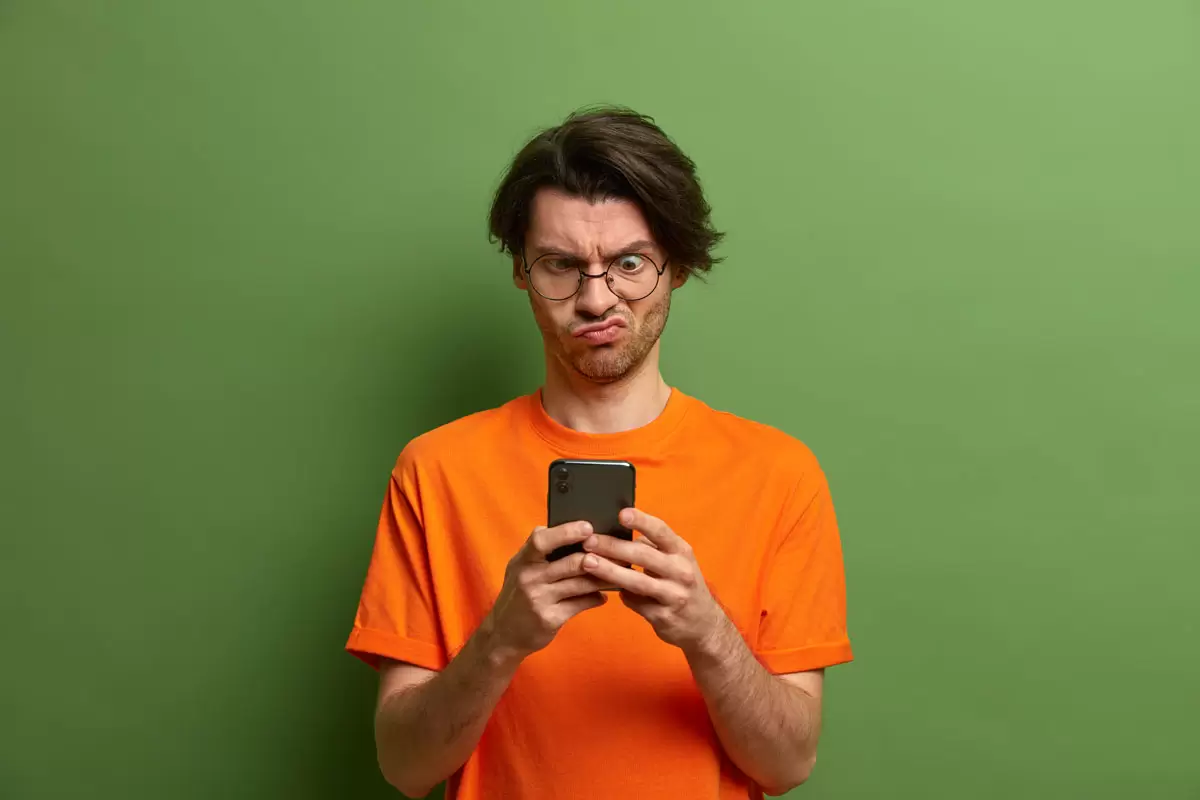 Homem fazendo cara feia porque seu Whatsapp foi clonado. Ilustra nosso artigo sobre clinar WhatsApp. Créditos da imagem: freepik.com