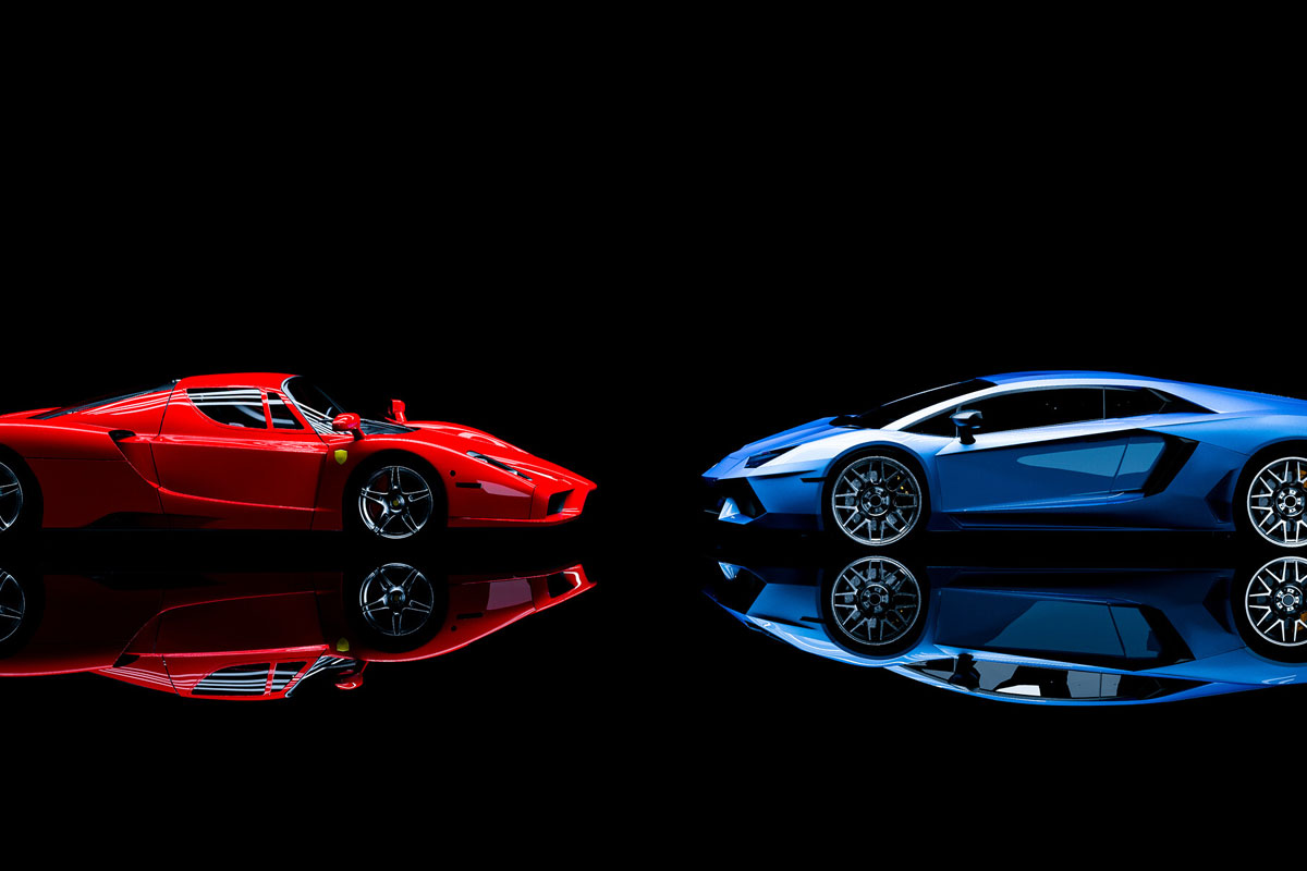 Uma Ferrari vermelha de frente para uma Lamborghini azul ilustrando nosso artigo sobre: Ferrari ou Lamborghini