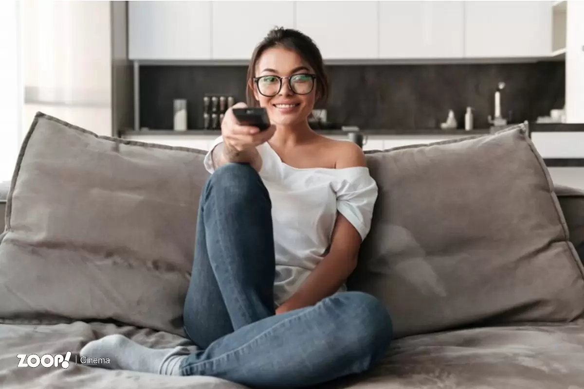 Mulher aponta controle remoto para a TV ilustrando nosso artigo sobre: Como Fazer Login no Star Plus. Mulher aponta controle remoto para a TV ilustrando nosso artigo sobre: Como Fazer Login no Star Plus.